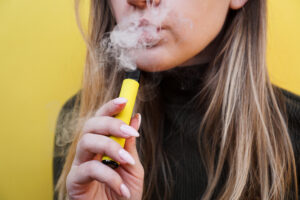 Vape Taste Burnt - A young girl smokes disposable electronic cigarette.